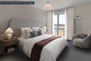 Modern bedroom with upholstered bed and reading chair at Brickmark Place, Bracknell