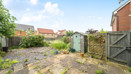 Rear patio area with paving slabs, fencing, shed, and surrounding houses.