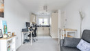 Open-plan living area with sofa, dining table and adjoining kitchen.