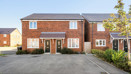 Red-brick semi-detached houses with driveway parking and a small tree outside.