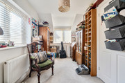 Second bedroom with a wooden chair, bookcase and shelving units.