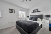 Bedroom with double bed, bedside tables, and neutral walls.
