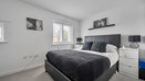 Bedroom with double bed, bedside tables, and neutral walls.
