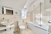 Bathroom with bath, shower screen, wash basin and toilet.