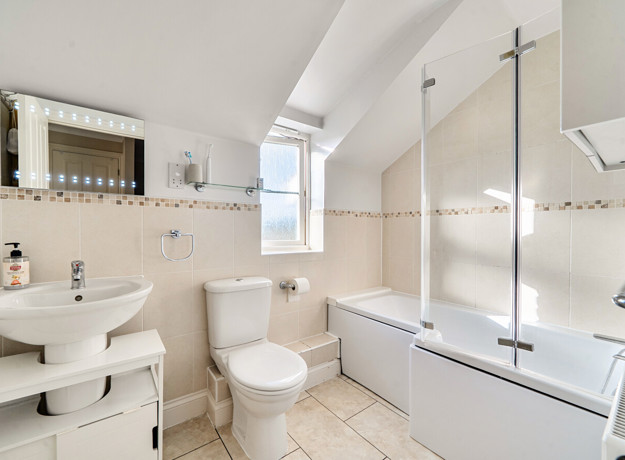 Bathroom with bath, shower screen, wash basin and toilet.