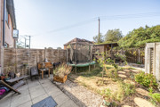 Rear garden with patio, lawn, fencing and outdoor seating area.