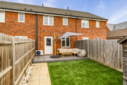 Rear garden with lawn, patio seating area and fenced boundaries.