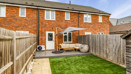 Rear garden with lawn, patio seating area and fenced boundaries.