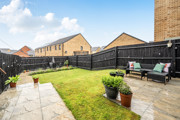 Patio and garden with seating, lawn area and fenced boundaries.