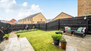 Patio and garden with seating, lawn area and fenced boundaries.
