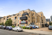 Exterior view of apartment building with balconies and resident parking.