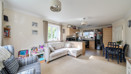 Open plan living area with sofas leading to dining space and kitchen.