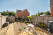 Rear garden with patio seating area, plants, shed and fenced boundaries.