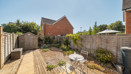 Rear garden with patio seating area, plants, shed and fenced boundaries.