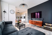 Living room with television, sofa, coffee table and kitchen beyond.