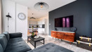 Living room with television, sofa, coffee table and kitchen beyond.