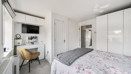 Double bedroom with wardrobes, desk and wall-mounted television.