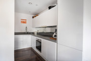 Compact white kitchen with fitted cabinets, worktops and built-in appliances.