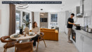 Modern open-plan apartment with contemporary kitchen, dining area and living room, featuring stylish furniture, large windows, and a resident preparing food in a bright, newly built home.