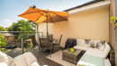 Patio with outdoor seating, a dining table and a large parasol.
