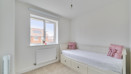 Second bedroom with single bed, white walls, window, and radiator below sill.