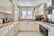Kitchen with fitted units, worktops, oven, hob and window with blinds.