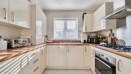 Kitchen with fitted units, worktops, oven, hob and window with blinds.