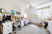 Bedroom with bed, desk, storage units and window.