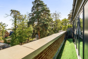 Balcony with overlooking trees and landscaped grounds.