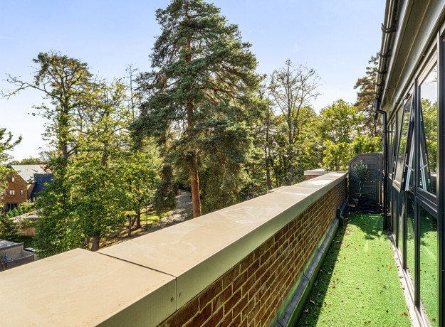 Balcony with overlooking trees and landscaped grounds.