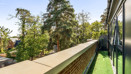 Balcony with overlooking trees and landscaped grounds.