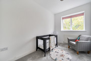Bedroom with a cot, armchair and window.