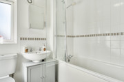 Bathroom with bath, shower screen, wash basin and mirror cabinet.
