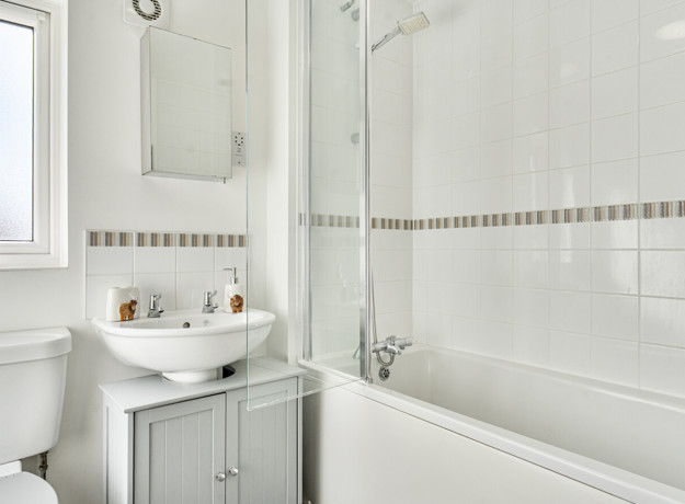 Bathroom with bath, shower screen, wash basin and mirror cabinet.