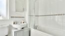 Bathroom with bath, shower screen, wash basin and mirror cabinet.