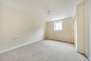 Bedroom with window, carpeted floor and built-in wardrobe.