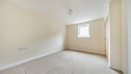 Bedroom with window, carpeted floor and built-in wardrobe.
