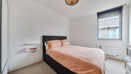 Bedroom with double bed, bedside table and window.
