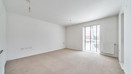 Living room with carpeted floor and floor-to-ceiling window.