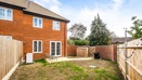 Rear elevation of a red-brick house with enclosed garden and patio.