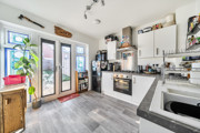 Kitchen with fitted units, appliances and patio doors to the garden.
