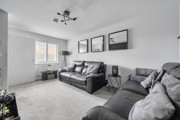 Living room with grey sofas, carpet, and framed pictures on wall.