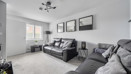 Living room with grey sofas, carpet, and framed pictures on wall.