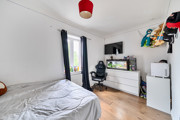 Bedroom with double bed, chest of drawers, television, chair, window and fish tank.