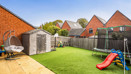 Rear garden with lawn, patio, shed and children's trampoline and slide.