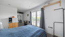 Bedroom with a double bed, wardrobe and balcony doors.