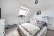 Bedroom with double bed, chest of drawers and roof window.