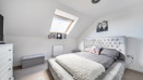 Bedroom with double bed, chest of drawers and roof window.