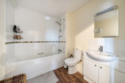Bathroom with bath, shower screen, sink and toilet.