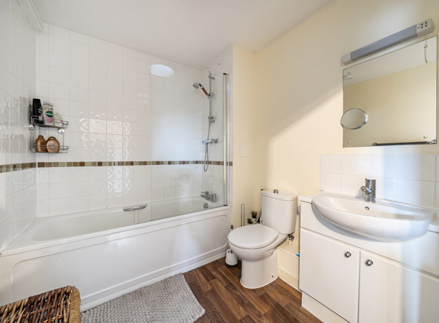 Bathroom with bath, shower screen, sink and toilet.